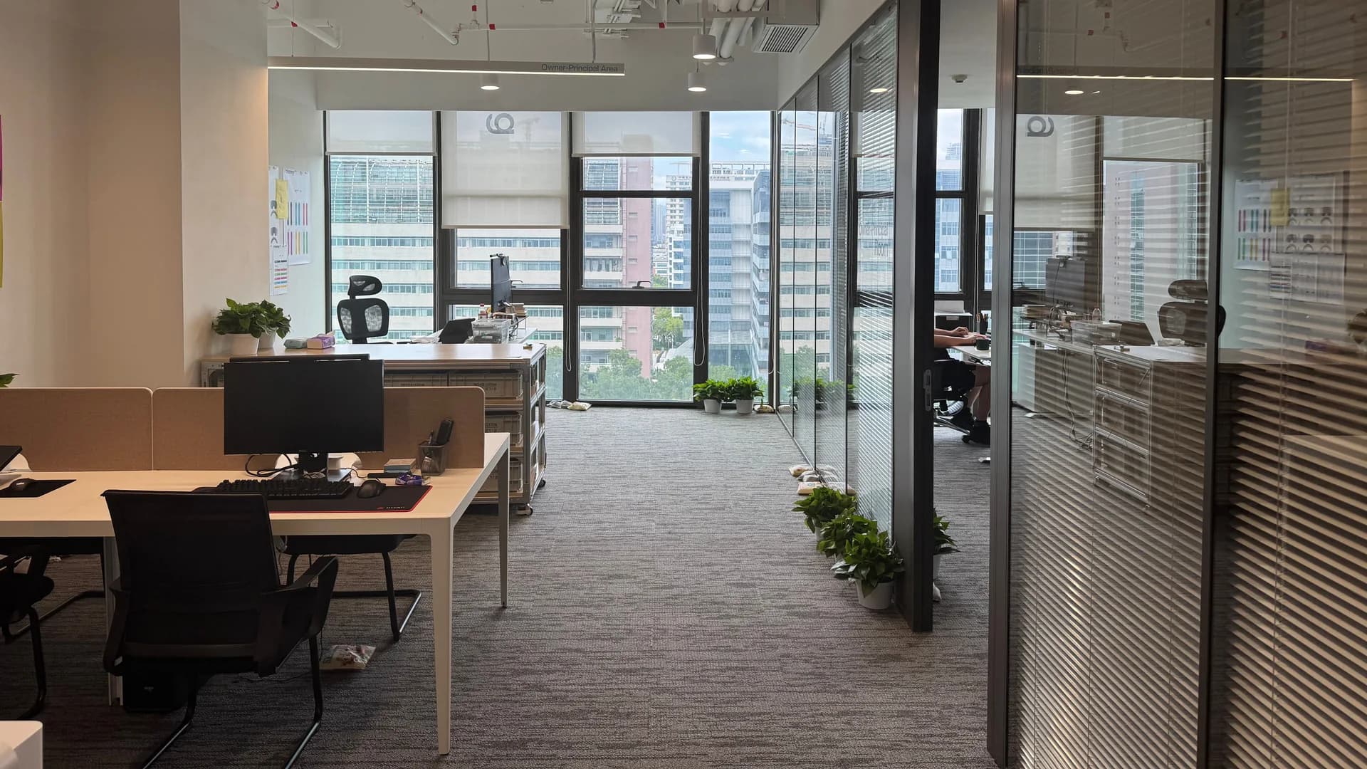 Helles modernes Büro mit großen Fenstern und gepflegten Arbeitsplätzen